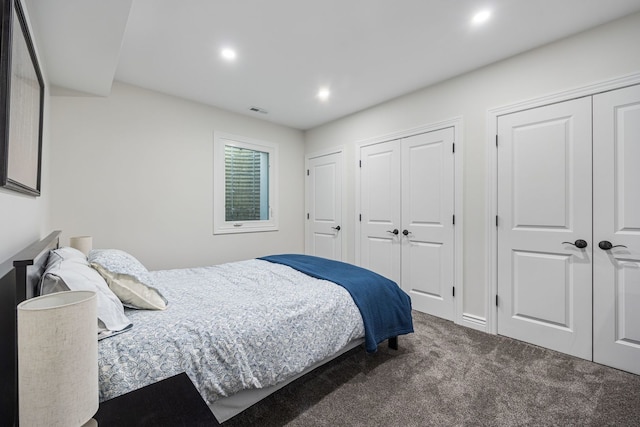 carpeted bedroom featuring recessed lighting, visible vents, and multiple closets