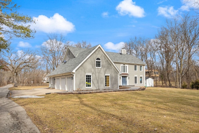 view of front of home with a front yard, fence, driveway, a shingled roof, and a chimney