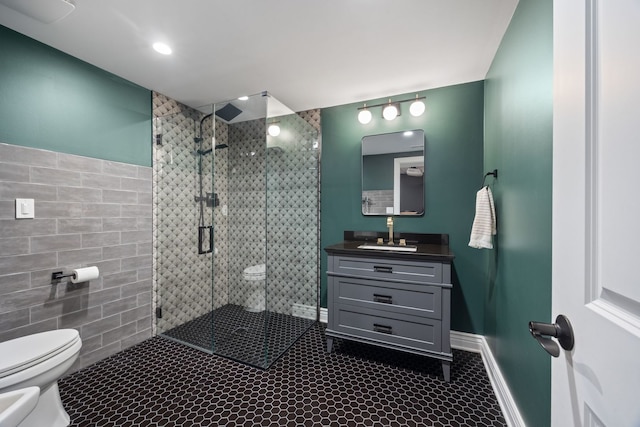 bathroom with toilet, a bidet, tile walls, a shower stall, and vanity