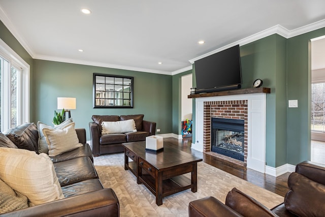 living room with plenty of natural light, a brick fireplace, and crown molding