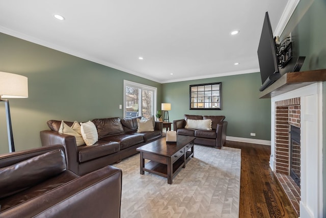 living area featuring baseboards, ornamental molding, recessed lighting, a fireplace, and wood finished floors