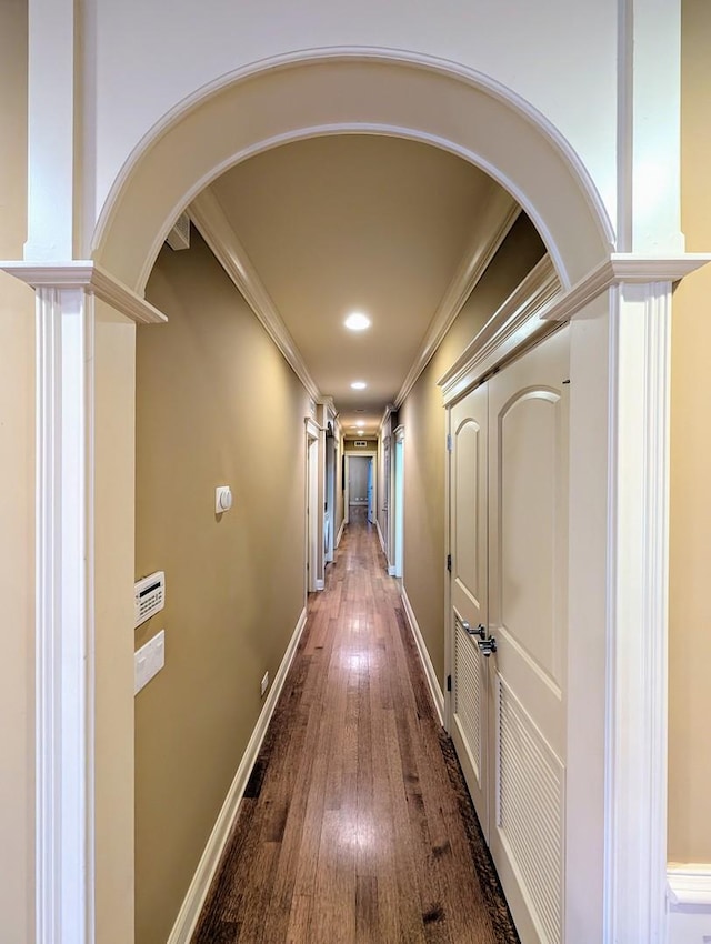 hallway featuring ornamental molding, wood-type flooring, and ornate columns