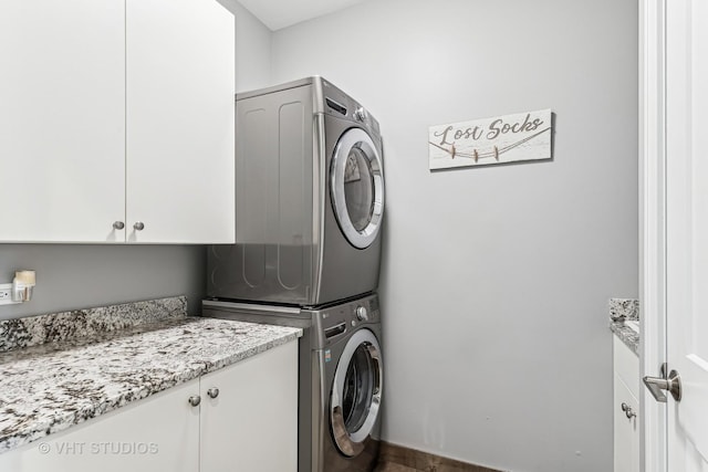 laundry area with stacked washer and dryer and cabinet space