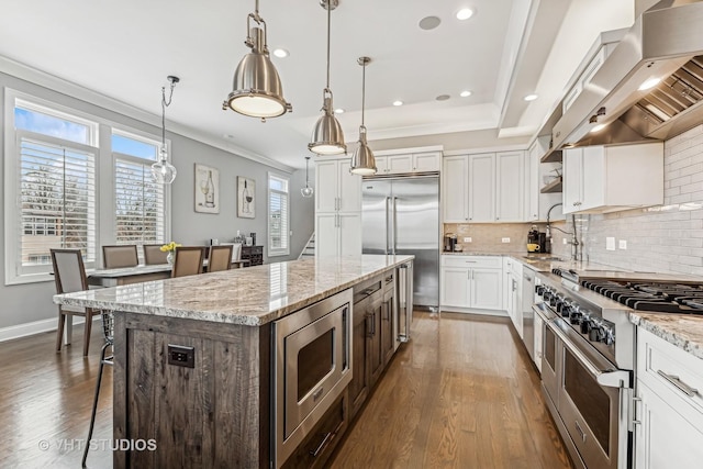 kitchen with range hood, decorative light fixtures, open shelves, white cabinets, and built in appliances