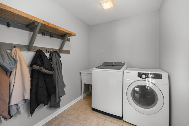 laundry area featuring light tile patterned flooring and washing machine and clothes dryer