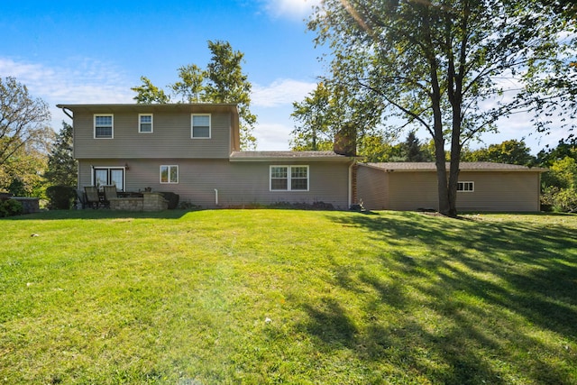 rear view of house featuring a yard