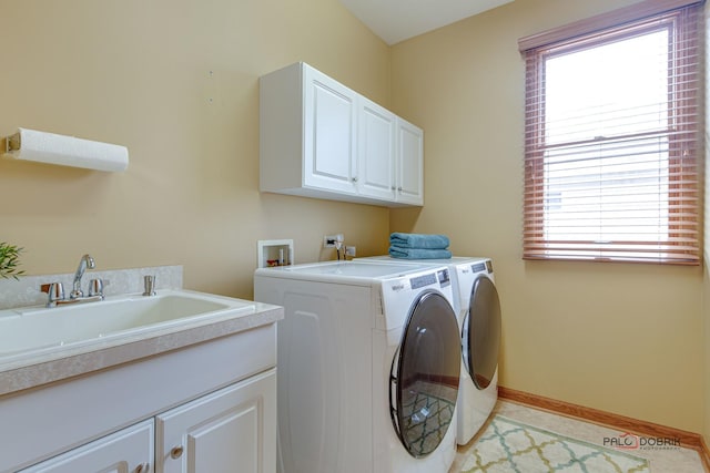 laundry room with cabinets, light tile patterned flooring, separate washer and dryer, and sink