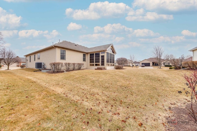 back of house with a sunroom, central AC, and a lawn