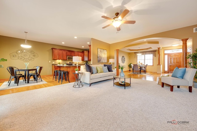 living room with ceiling fan, light colored carpet, and ornate columns