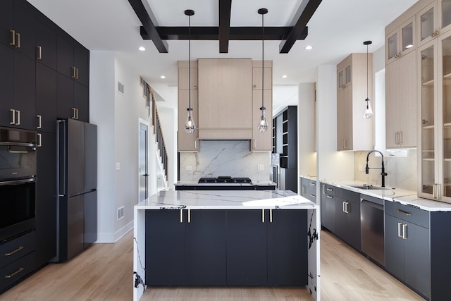 kitchen featuring a kitchen island, appliances with stainless steel finishes, pendant lighting, and a sink