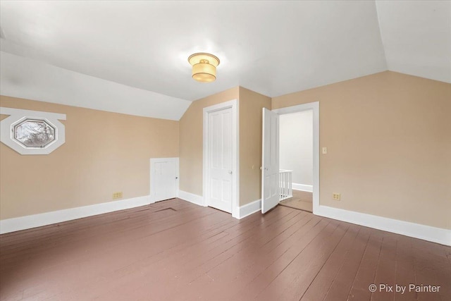 additional living space with dark hardwood / wood-style flooring and vaulted ceiling