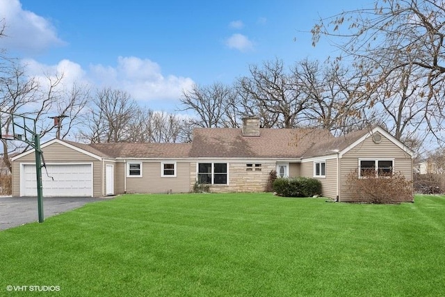 view of front of house with a yard, an attached garage, a chimney, and aphalt driveway