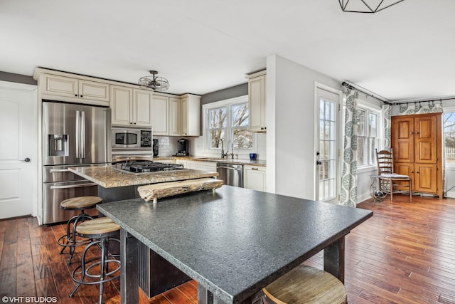 kitchen featuring dark wood-type flooring, cream cabinetry, and appliances with stainless steel finishes