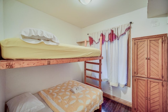 bedroom with dark hardwood / wood-style flooring