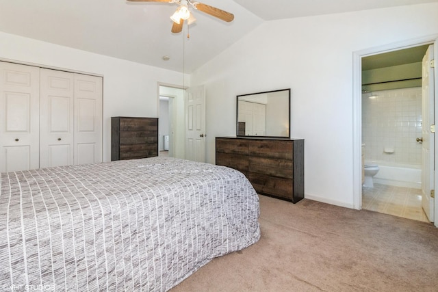 carpeted bedroom featuring connected bathroom, vaulted ceiling, a closet, and ceiling fan