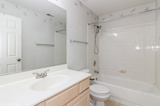 full bathroom featuring tiled shower / bath combo, vanity, and toilet