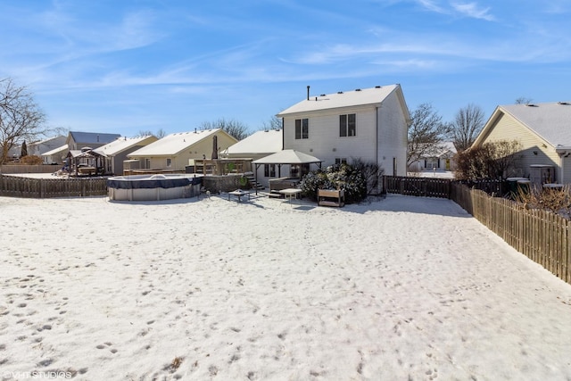 snow covered rear of property with a gazebo and a covered pool