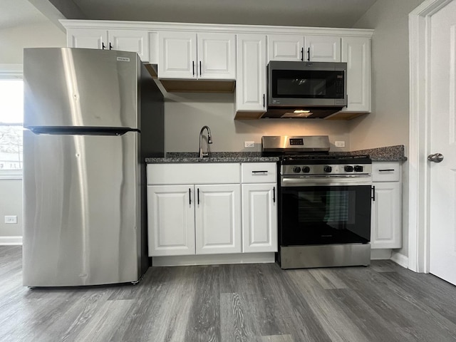 kitchen featuring wood-type flooring, appliances with stainless steel finishes, sink, and white cabinets