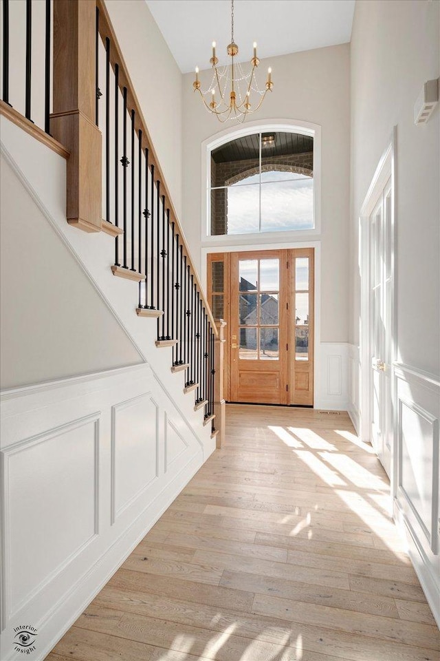 entrance foyer featuring a high ceiling, a chandelier, and light hardwood / wood-style flooring