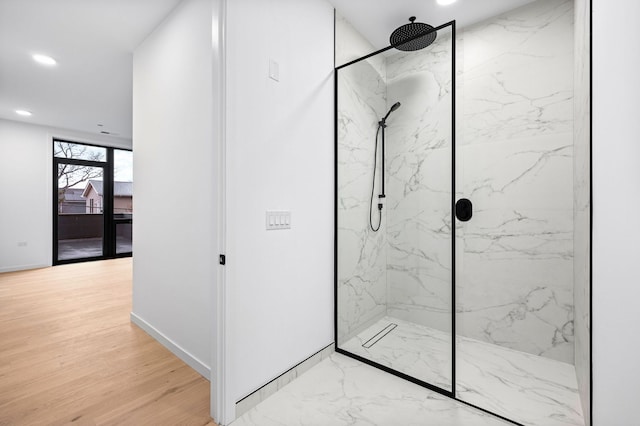 bathroom with hardwood / wood-style floors and a tile shower