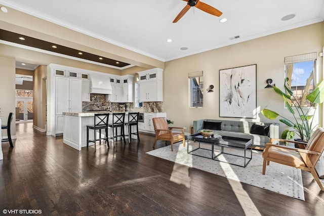 living room featuring recessed lighting, visible vents, a ceiling fan, ornamental molding, and dark wood finished floors