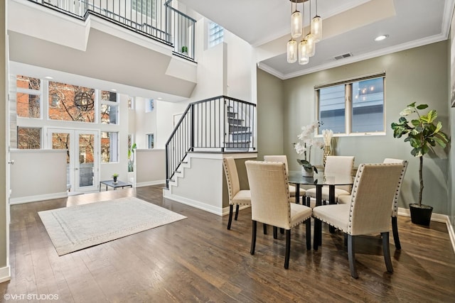 dining room featuring french doors, hardwood / wood-style flooring, a chandelier, baseboards, and stairs