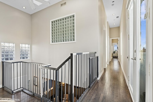 corridor with recessed lighting, visible vents, wood finished floors, and an upstairs landing