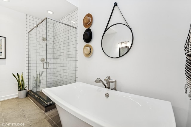 bathroom featuring recessed lighting, a shower stall, a freestanding tub, baseboards, and tile patterned floors