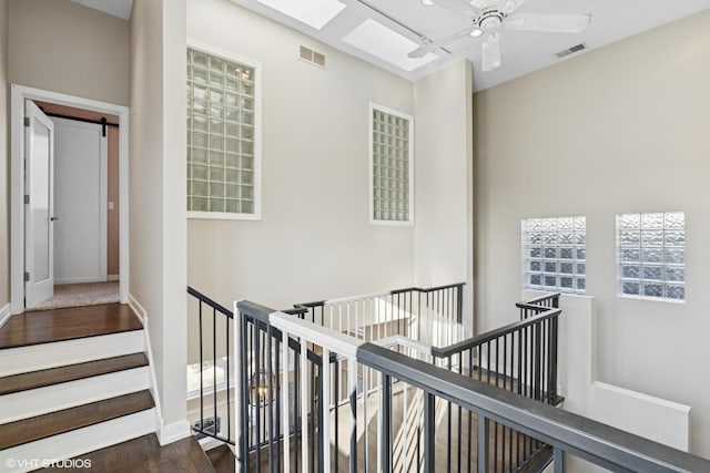 corridor featuring a barn door, visible vents, and an upstairs landing