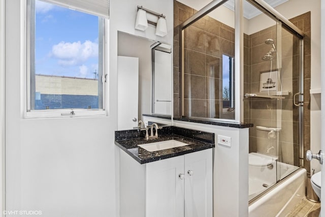 full bathroom with bath / shower combo with glass door, vanity, and toilet