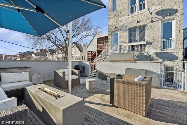 wooden terrace featuring stairway and an outdoor living space with a fire pit