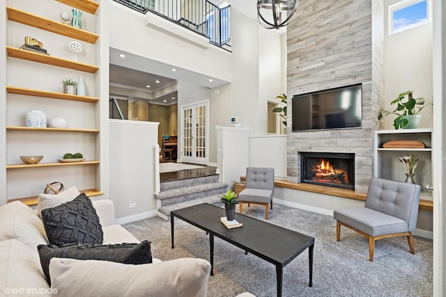 living room with carpet floors, a high ceiling, a fireplace, baseboards, and stairway