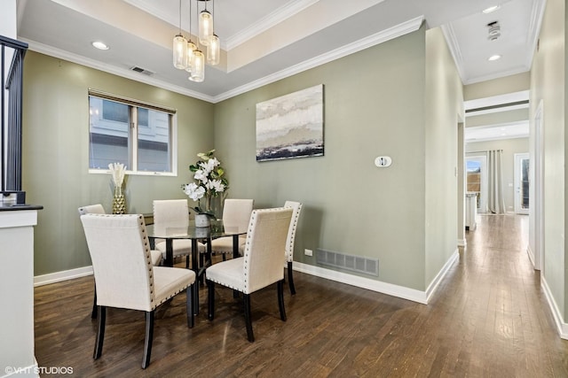 dining area with visible vents, crown molding, and wood finished floors