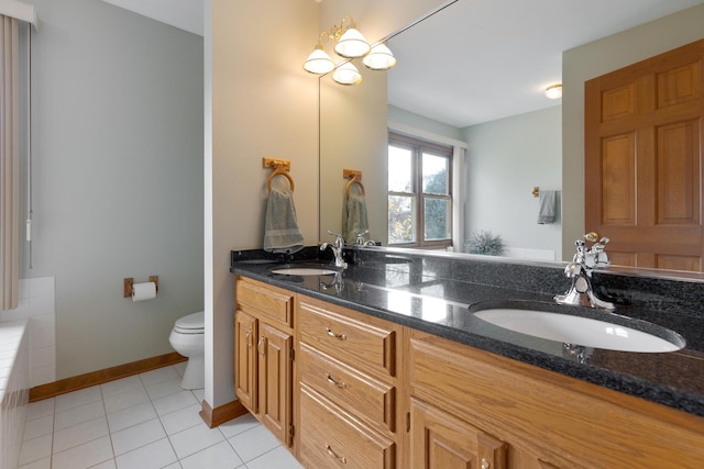 bathroom with tile patterned floors, a sink, toilet, and double vanity