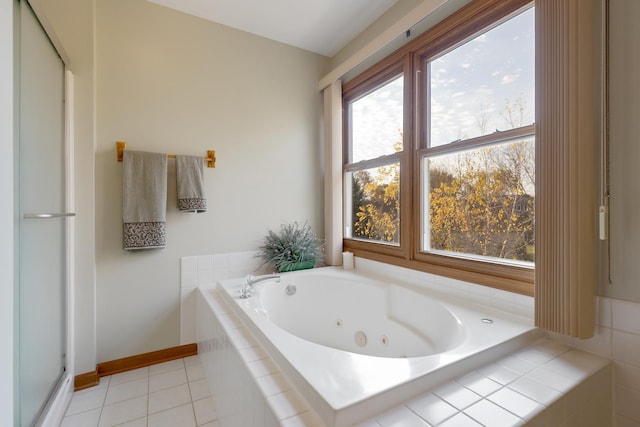 bathroom featuring baseboards, a tub with jets, and tile patterned floors