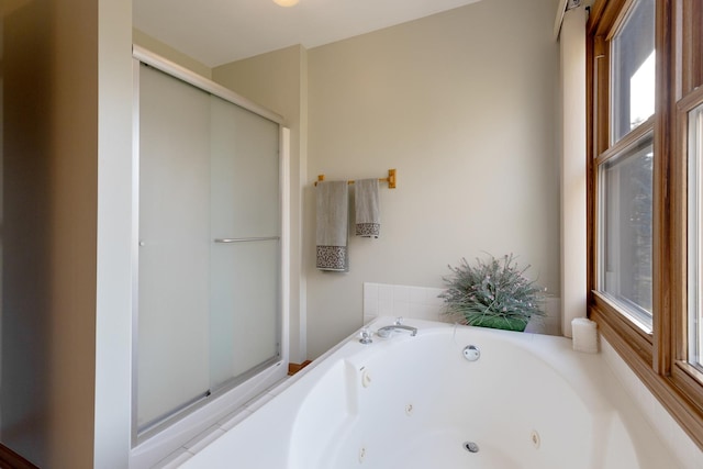 full bath with a healthy amount of sunlight, a stall shower, and a jetted tub