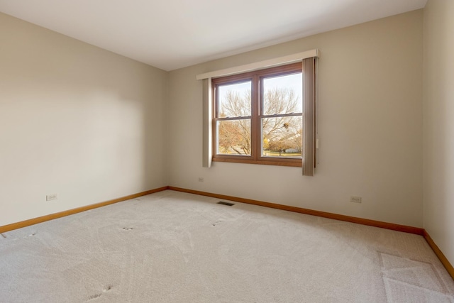 unfurnished room featuring carpet, visible vents, and baseboards