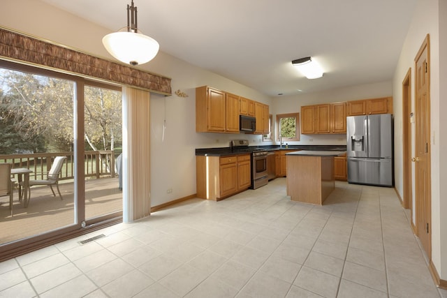 kitchen featuring a kitchen island, visible vents, hanging light fixtures, appliances with stainless steel finishes, and dark countertops