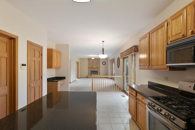 kitchen with black microwave, a fireplace, open floor plan, stainless steel range with gas cooktop, and decorative light fixtures