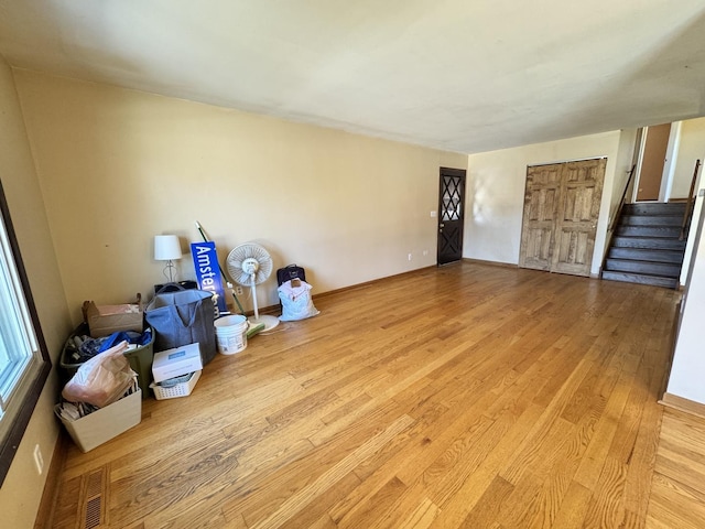 interior space with light wood-style flooring, visible vents, and stairway