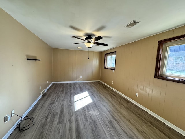 spare room featuring visible vents, baseboards, and wood finished floors