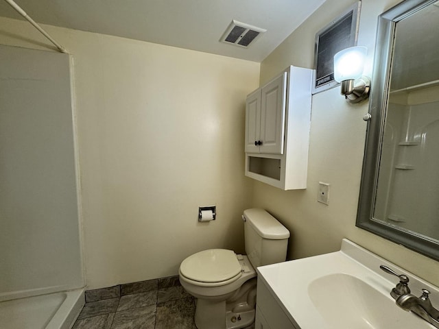 bathroom with toilet, a shower, vanity, and visible vents