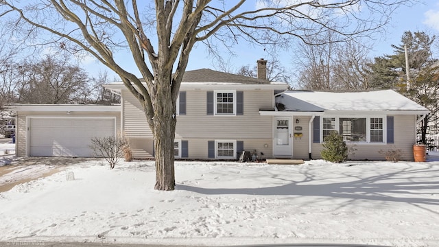 split level home with a chimney and an attached garage