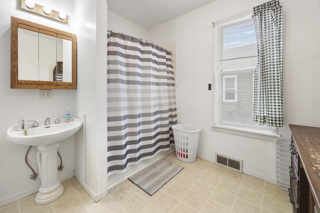 full bath featuring a shower with curtain, tile patterned floors, visible vents, and baseboards