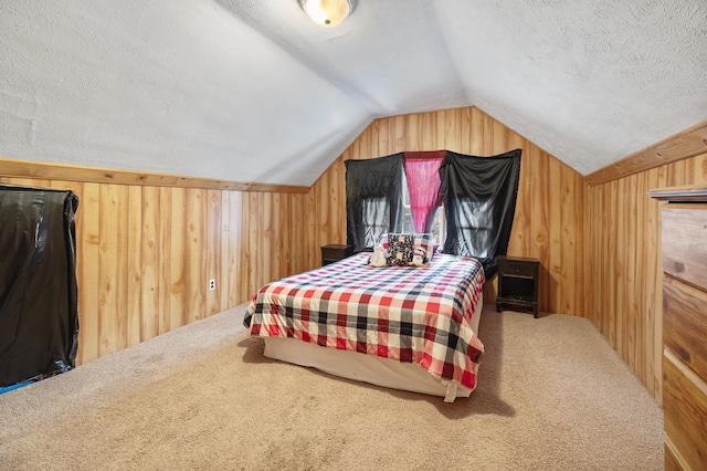 bedroom featuring lofted ceiling, carpet flooring, wood walls, and a textured ceiling