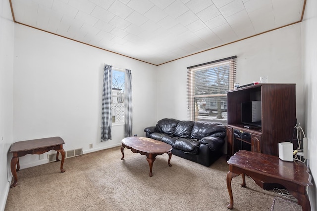 living room featuring carpet flooring, crown molding, visible vents, and baseboards