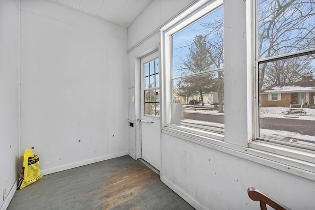 doorway featuring wood-type flooring and baseboards