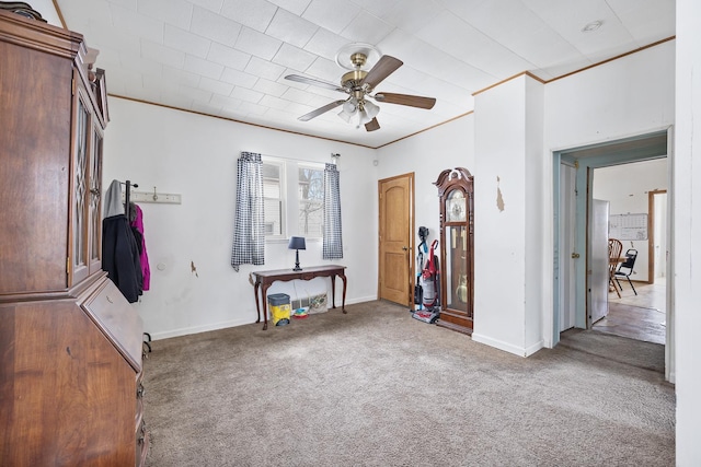 misc room with carpet floors, crown molding, baseboards, and a ceiling fan