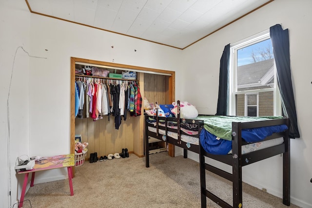 bedroom with ornamental molding, carpet, and a closet