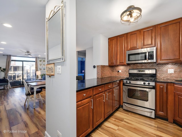 kitchen with stainless steel appliances, light wood finished floors, brown cabinetry, and decorative backsplash